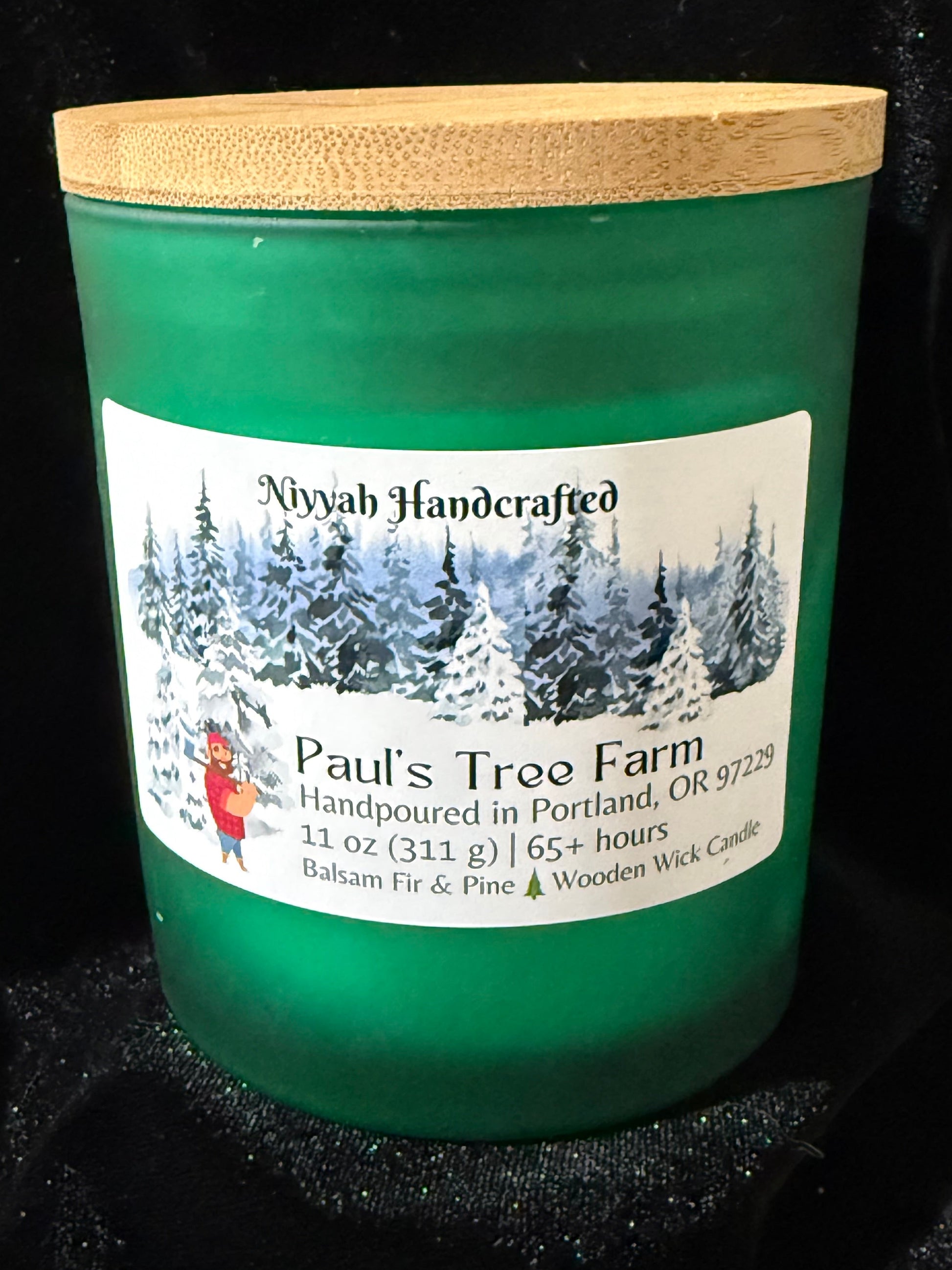 Green candle with a label on a black background